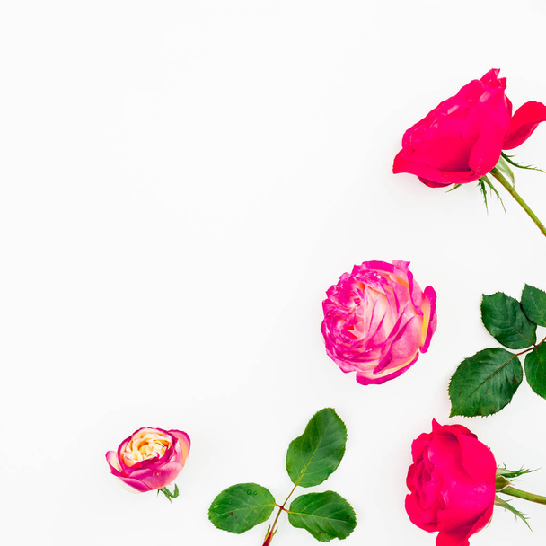Růžové růže květiny a zelené listy na bílém pozadí. Plochá ležel, horní pohled s kopií prostor - Fotografie, Obrázek