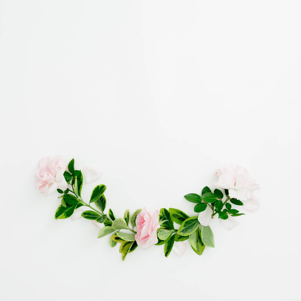 Composición floral de rosas y hojas verdes sobre fondo blanco. Piso tendido, vista superior
. - Foto, imagen
