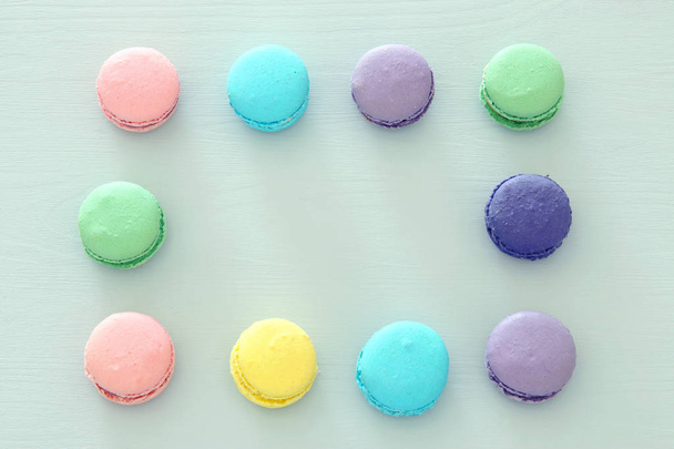 Top view of colorful macaron or macaroon over pastel blue background. Flat lay - Фото, изображение