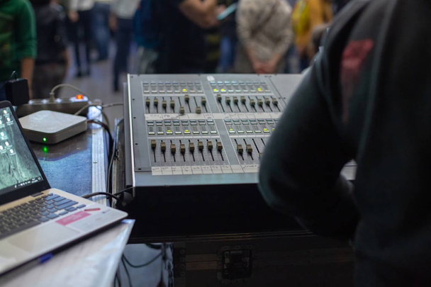 Soundman trabajando en la consola de mezclas detrás de la multitud del concierto. Vista desde atrás
. - Foto, imagen