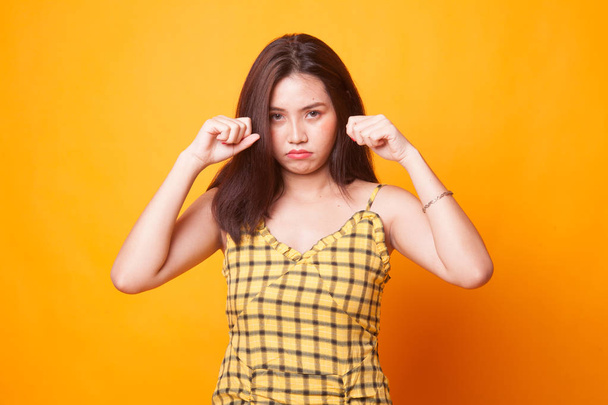 Young Asian woman sad and cry on yellow background - Foto, Imagem