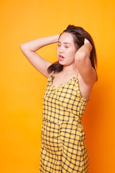 Stressed young Asian businesswoman scream out on yellow background - Foto, Imagen