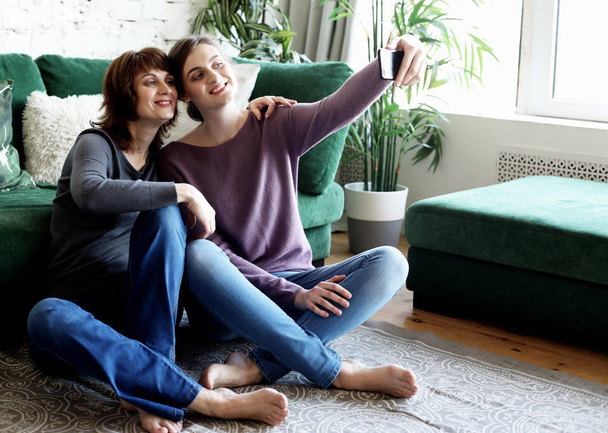 mature mother and her daughter making a selfie using smart phone - Valokuva, kuva