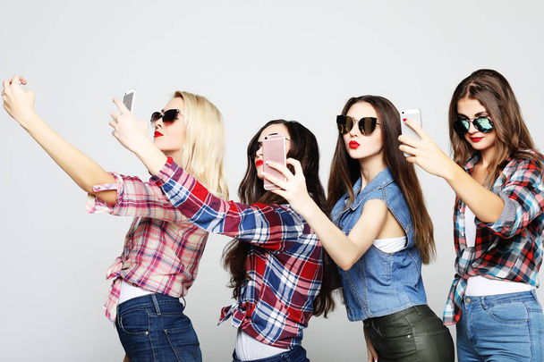 friendship, people and technology concept - four happy teenage girls with smartphone taking selfie - Photo, image