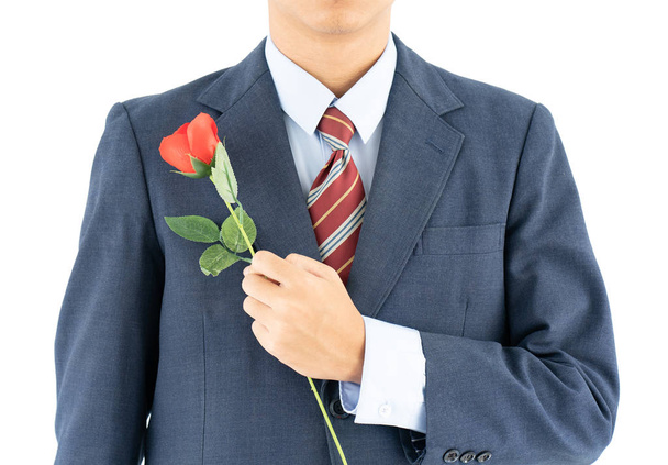 Detail fotografie obchodníka v obleku držení s červenou růží na bílém pozadí - Fotografie, Obrázek