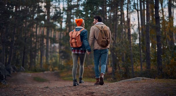 Young couple of tourists are exploring new places. Attractive young woman and handsome bearded man are spending time together on nature. - Foto, Imagen