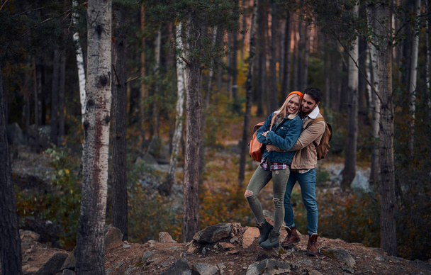 Молодая пара туристов осматривает новые места. Привлекательная молодая женщина и красивый бородатый мужчина проводят время вместе на природе
. - Фото, изображение