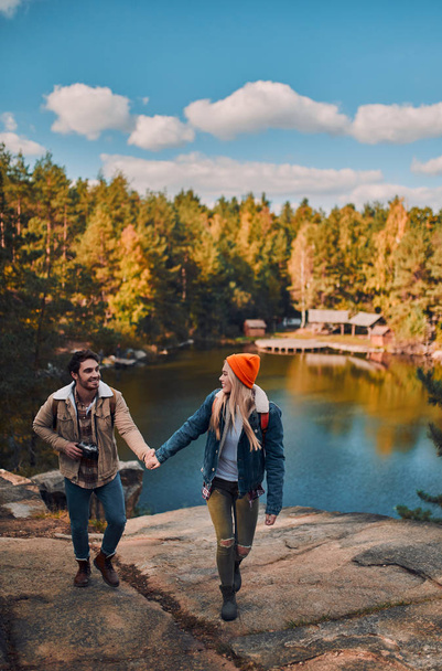 Young couple of tourists are exploring new places. Attractive young woman and handsome bearded man are spending time together on nature. - Valokuva, kuva