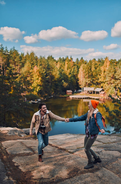 Young couple of tourists are exploring new places. Attractive young woman and handsome bearded man are spending time together on nature. - Fotó, kép
