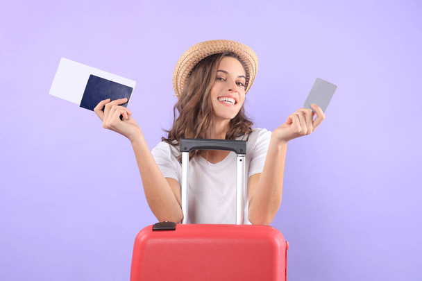 Tourist girl in showing plastic credit card with sunglasses, red suitcase, passport isolated on purple background. - Foto, Bild