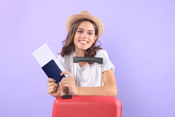 Young tourist girl in summer casual clothes, with sunglasses, red suitcase, passport isolated on purple background. - Foto, Imagen