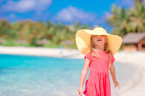entzückendes kleines Mädchen mit Hut am Strand während der Sommerferien - Foto, Bild