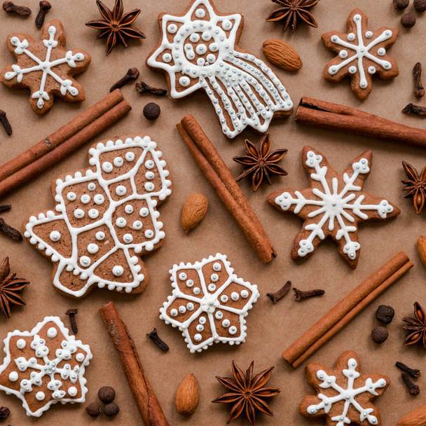 Christmas dekoration with spices and cookies in the shape of snowflakes on dark brown paper background. Top view. - Foto, imagen