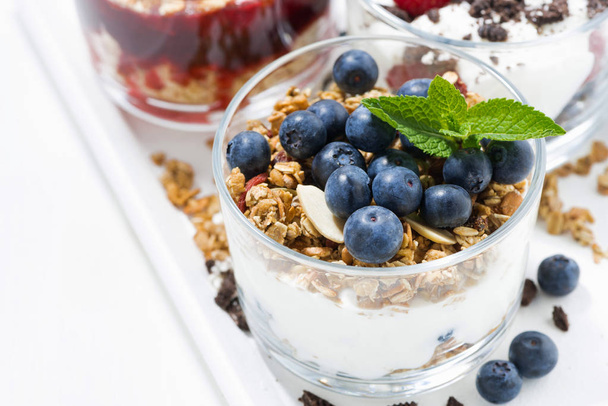sweet desserts with fresh berries in glasses on white table, closeup, horizontal - Φωτογραφία, εικόνα