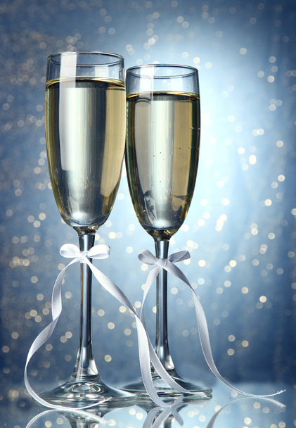 Two glasses of champagne on bright background with lights - 写真・画像