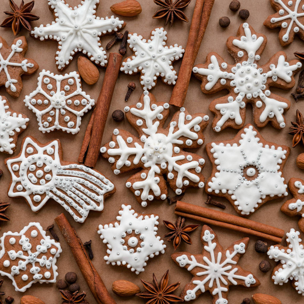 Christmas dekoration with spices and cookies in the shape of snowflakes on dark brown paper background. Top view. - Foto, immagini
