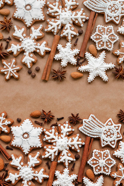 Christmas dekoration with spices and cookies in the shape of snowflakes on dark brown paper background. Top view. - Фото, зображення