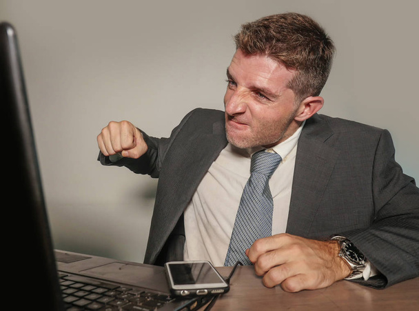young stressed and overwhelmed businessman in suit and tie working angry at office laptop computer desk looking furious and upset in financial business stress problem at corporate job  - Photo, Image