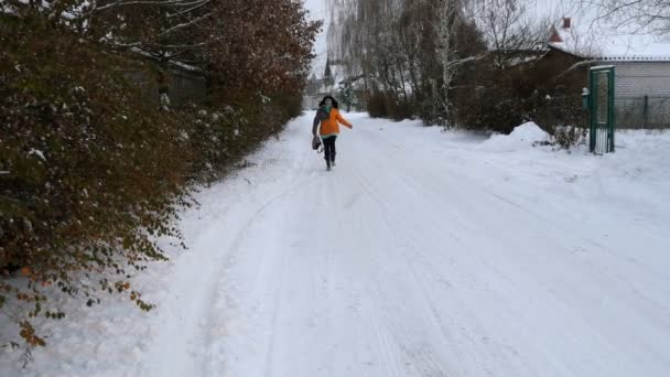 Yetişkin kadın eğlenceli kırsal kesimde karlı bir yol boyunca yürüyüş. - Video, Çekim