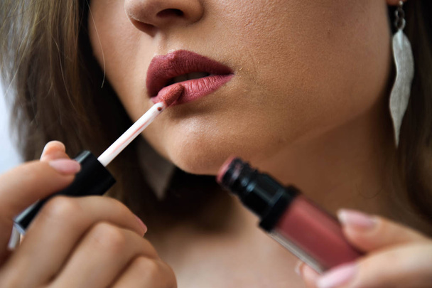 The girl is painting lipstick lips - Fotografie, Obrázek