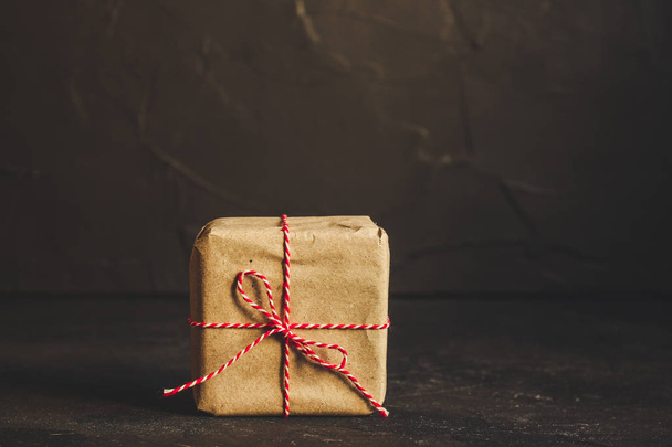 Caja de regalo con cinta - papel artesanal (fondo oscuro). vista superior, espacio de copia
 - Foto, Imagen