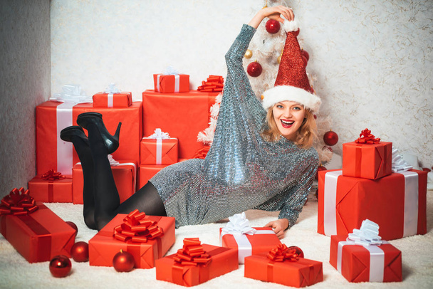 Christmas decorations and gift box on wooden background. Christmas dresses. Funny Laughing Surprised Woman Portrait. Comic grimace. Smiling girl winter. - Fotoğraf, Görsel