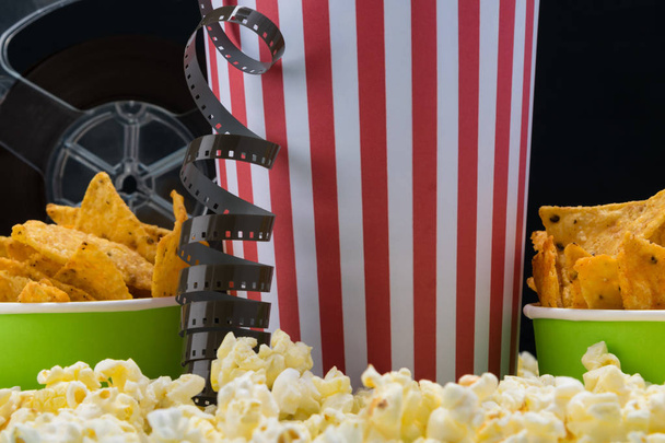 on the background of popcorn are paper cups with chips for watching movies - Foto, afbeelding