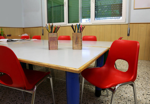 iç kırmızı sandalye ve çocuksuz masada üzerinde kalem ile bir okulun okul sınıf - Fotoğraf, Görsel