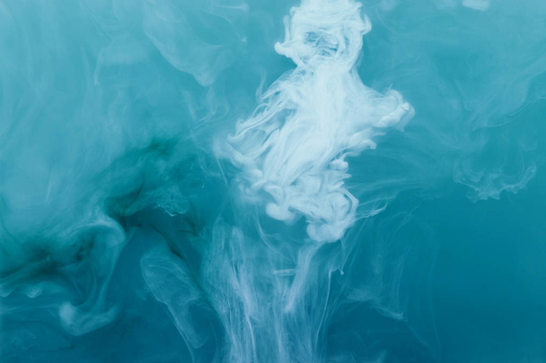 Синий и белый акриловые краски внутри воды на синем фоне. Акварель и абстрактное изображение моря или океана
. - Фото, изображение