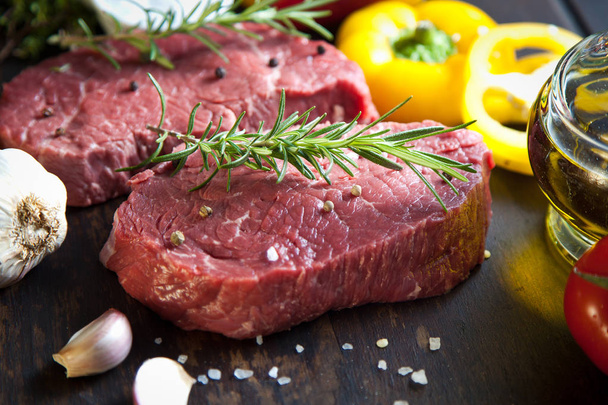 Raw beef steak on a dark wooden table. - Foto, immagini