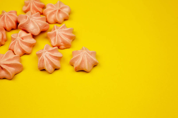 Multi-colored mini-meringues on a yellow background, top view. Place for text. - Φωτογραφία, εικόνα