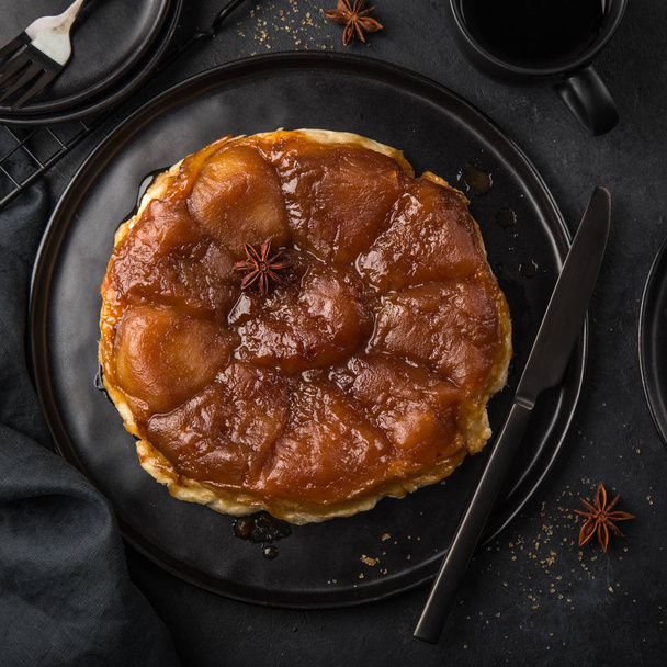 apple tart tatin, french caramel upside down cake, black background, top view, square image - Fotografie, Obrázek