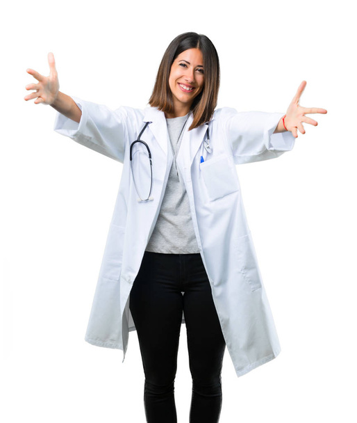 Ärztin mit Stethoskop präsentiert und lädt ein, mit der Hand zu kommen. glücklich, dass Sie auf isoliertem weißen Hintergrund kamen - Foto, Bild