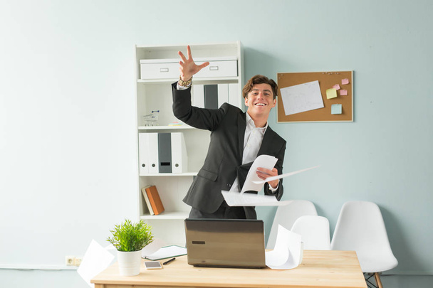 Obchodní lidé, vtip a zábava koncept - mladý pohledný muž v obleku baví v kanceláři - Fotografie, Obrázek