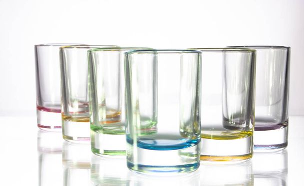 Six petits verres colorés sur fond blanc en gros plan
 - Photo, image