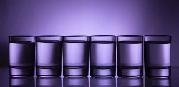 Six small multi-colored glasses on a bright background close up - Foto, Bild