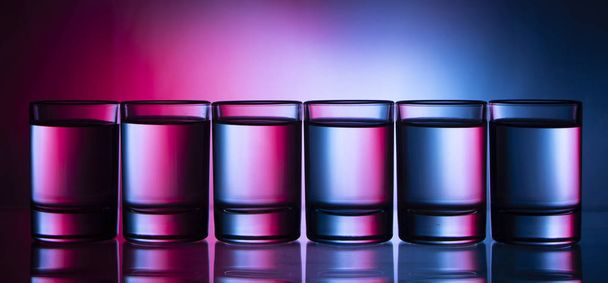 Six small multi-colored glasses on a bright background close up - Photo, image
