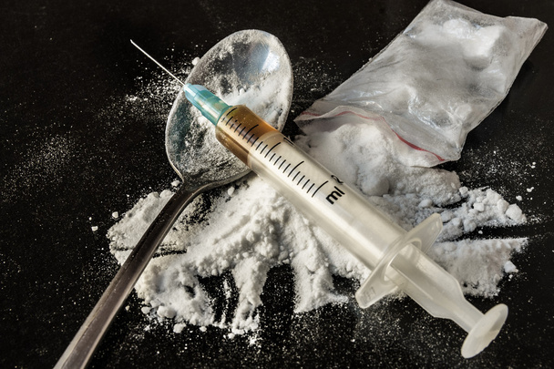 Drug syringe and cooked heroin on spoon - Valokuva, kuva