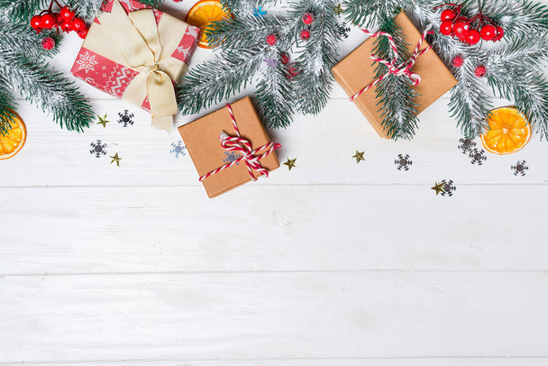 Старый деревянный фон с еловыми ветвями. Праздничные подарки. Рождественская открытка Вид сверху. Подарки коробки с еловыми ветвями на деревянном фоне
 - Фото, изображение