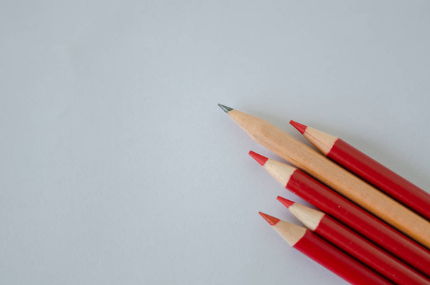 Many group of red pencils but yellow color pencil standing out from crowd of plenty identical, leadership, independence, uniqueness, initiative, initiative, think different, business success concept isolated - Photo, Image