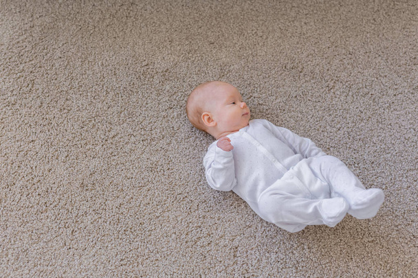 Család, gyerekkor koncepció - közelről a szép baba fekszenek a padlón álló - Fotó, kép