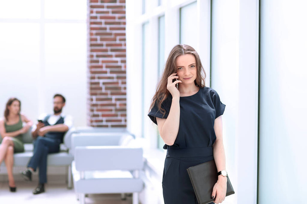 young woman uses her smartphone in the office - Фото, изображение