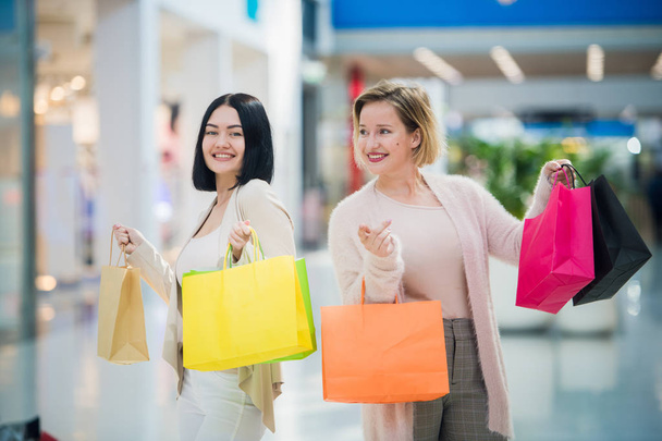 Due belle giovani donne in un centro commerciale a controllare le borse
 - Foto, immagini