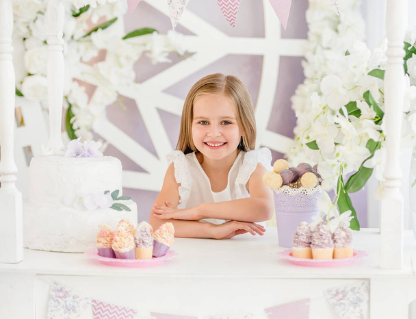 Little girl holding a sweet cake in the candy bar - Fotó, kép