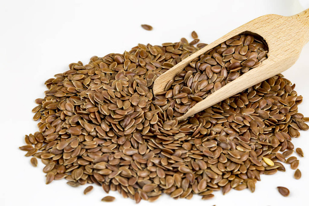 Linum usitatissimum is scientific name of Brown Flax seed. Also known as Linseed, Flaxseed and Common Flax. Pile of grains, isolated white background. - Photo, Image
