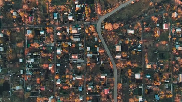 Luchtfoto rotatie van de camera over een grote stad met huizen en een dure dag op een zonnige herfstdag - Foto, afbeelding