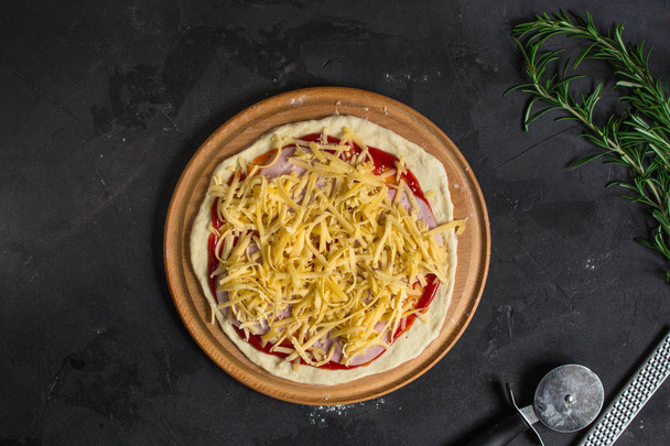 pizza, pâte, ingrédients, pepperoni, fromage, sauce toatny (processus de cuisson). Vue supérieure avec espace de copie
  - Photo, image