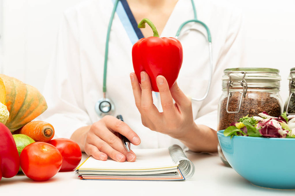 Pflanzliche Ernährung und Medikamentenkonzept. Ernährungswissenschaftlerin bietet gesunde Gemüsekost. - Foto, Bild