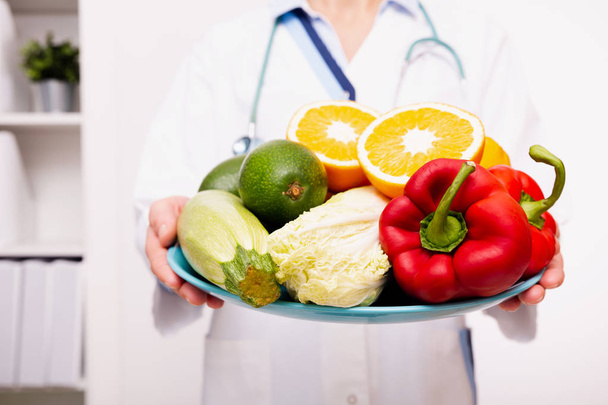 Plantaardige voeding en medicatie concept. Voedingsdeskundige biedt gezonde groenten dieet. - Foto, afbeelding