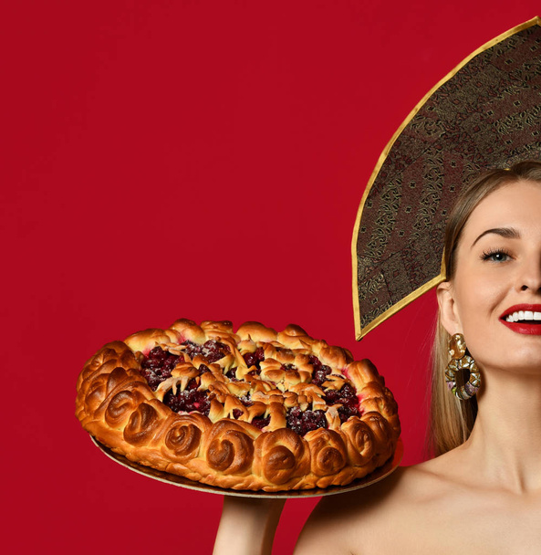 Woman in Russian traditional cap hat kokoshnik happy smiling hold sweet cherry homemade pie tasty bun - 写真・画像